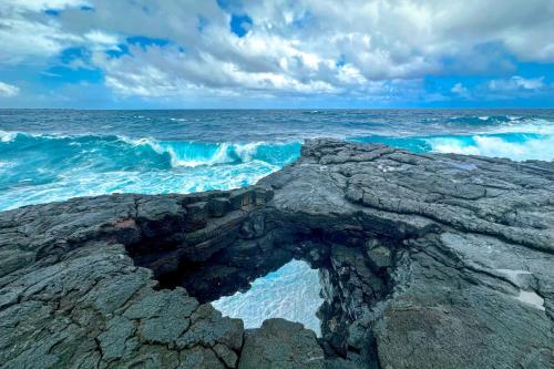 a rock formation on the ocean with the waves at Direct Oceanfront, Big Island Home in Keaau