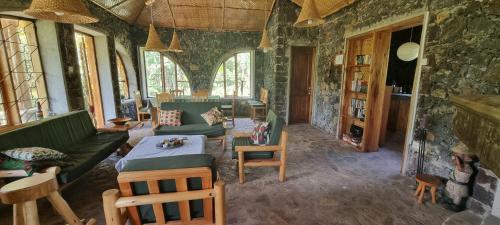uma sala de estar com um sofá e uma mesa em Mutolere Coffee Pot Guest Houses em Kisoro