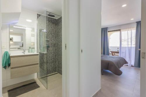 uma casa de banho com chuveiro e uma cama num quarto em Luxury duplex in Los Cristianos , 6 pax em Los Cristianos