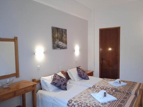 a hotel room with two beds with towels on them at Villa Kaloudis Rooms in Agios Georgios