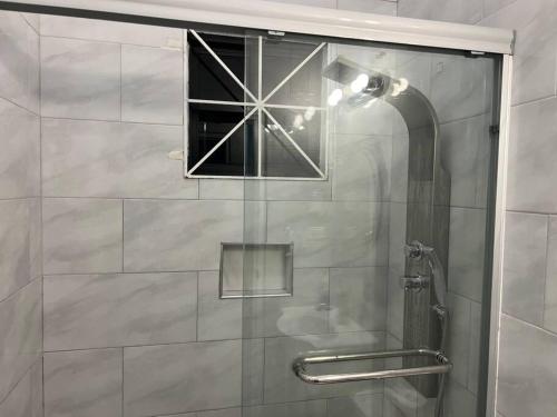 a glass shower door with a window in a bathroom at Luxury 1 Bedroom & Rooftop Pool unit #2 in Falmouth
