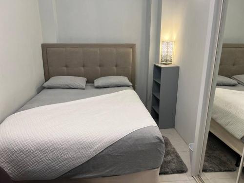 Dormitorio pequeño con cama y espejo en Luxury 1 Bedroom & Rooftop Pool unit #2, en Falmouth