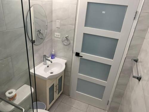 a bathroom with a sink and a mirror and a shower at Luxury 1 Bedroom & Rooftop Pool unit #2 in Falmouth