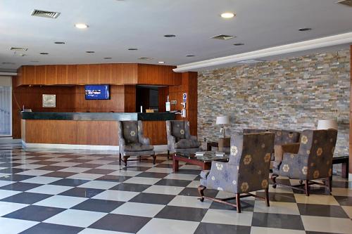 a lobby with a waiting room with chairs and a bar at Hotel Diego de Almagro Iquique in Iquique