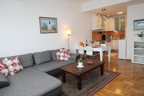 ザグレブにあるApartment Elena 2 Zagreb City with garageのソファとテーブルとキッチンのあるリビングルーム