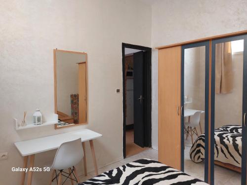 a bedroom with a bed and a desk and a mirror at Appartement entier à une chambre à coucher in Agadir