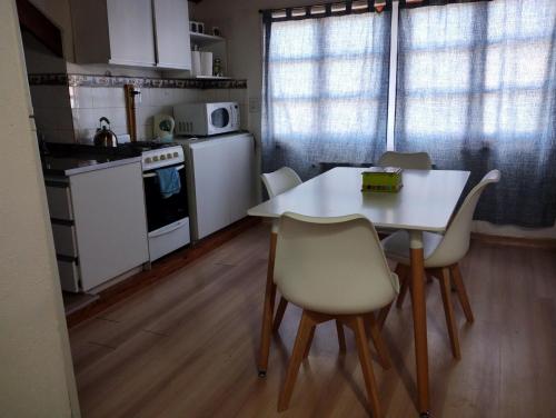 een keuken met een witte tafel en stoelen in een kamer bij Lo de Mily in Ushuaia
