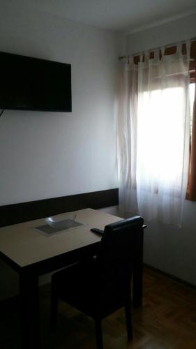 a room with a table and a chair and a window at Eros apartmani in Zlatibor