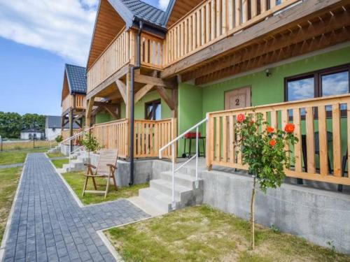 a wooden house with a porch and stairs to it at Mieleńskie Piaski in Mielno