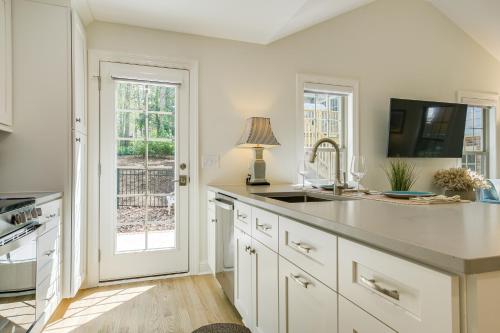 a kitchen with white cabinets and a sink and a window at Beautiful Raleigh Cottage Rental 5 Mi to Downtown in Raleigh