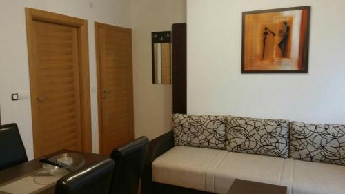 a living room with a couch and a table at Eros apartmani in Zlatibor