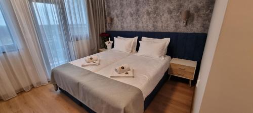 a bedroom with a large bed with two towels on it at Park Hotel Viasport in Gorni Dŭbnik