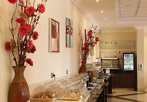 a kitchen with a buffet line with red flowers at Hotel Diego de Almagro Iquique in Iquique