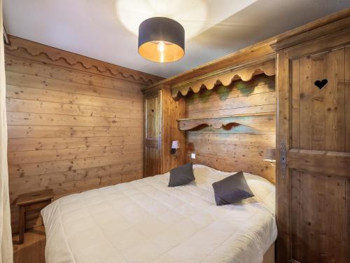 une chambre avec un lit dans un mur en bois dans l'établissement Appartement cosy ski aux pieds avec piscine et spa - FR-1-566-46, à Les Allues