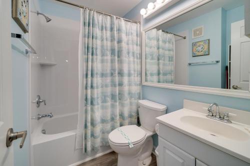 a bathroom with a toilet and a sink and a shower at Oceanfront Carolina Beach Condo with Pool and Views! in Carolina Beach
