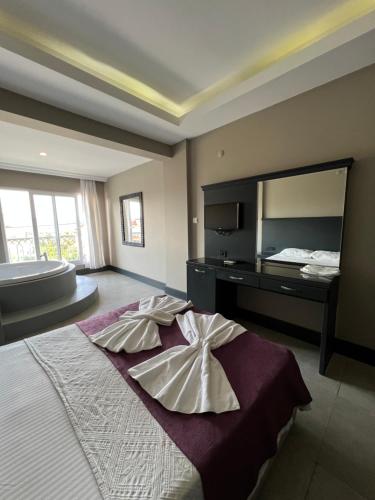 a bedroom with a large bed with a large mirror at İzmah Apart Ölüdeniz in Fethiye