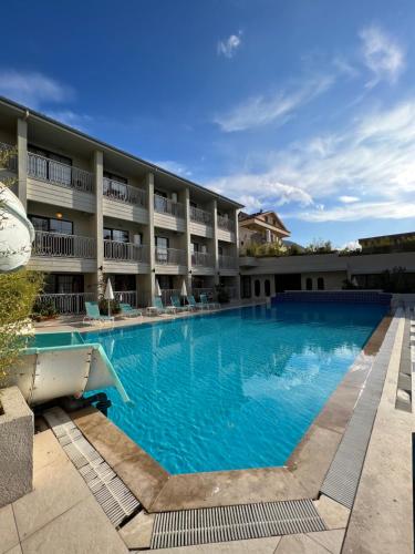 a large swimming pool in front of a hotel at İzmah Apart Ölüdeniz in Fethiye