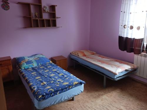 2 camas individuales en una habitación con paredes moradas en Jak w Domu, en Lubaczów