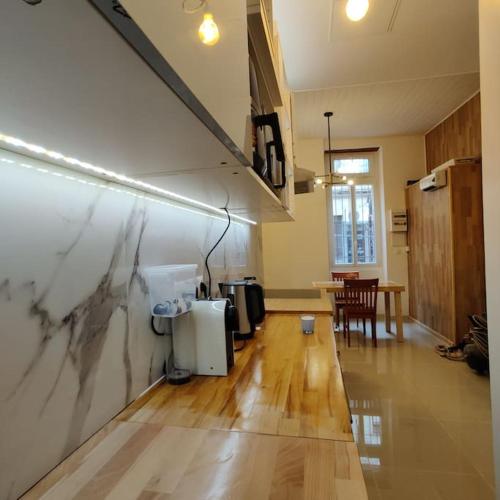 - un salon avec un mur en marbre et du parquet dans l'établissement T2 cosy Jean Jaurès et Gare Matabiau, à Toulouse