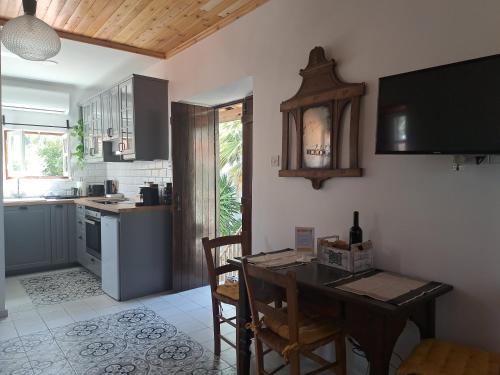 a kitchen with a table and chairs and a kitchen with a counter at Liakoto in Panayia