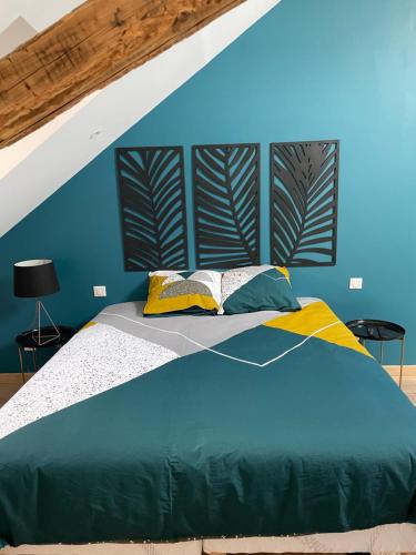 une chambre avec des murs bleus et un grand lit dans l'établissement La Belle Mira vous attend !, à Metz