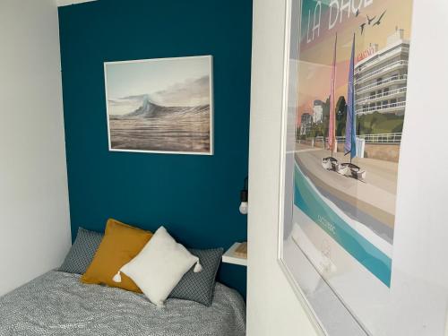 Un dormitorio con una pared de acento azul y una cama en La Capitane en La Baule