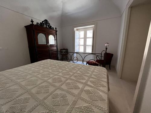 1 dormitorio con 1 cama, vestidor y ventana en Palazzo Triolo - Dimora di Charme, en Corleone