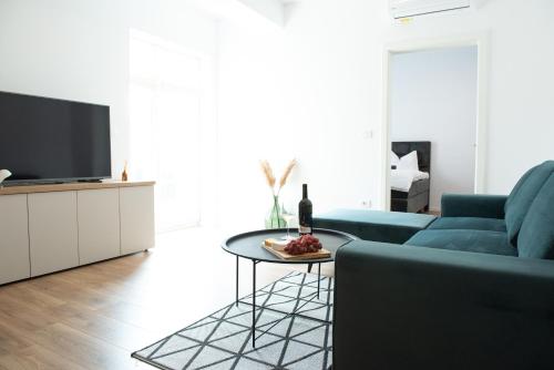 a living room with a blue couch and a table at Alternativ 2 Residence Central in Timişoara