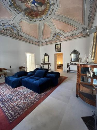 a large bedroom with a large blue bed and a ceiling at Palazzo Triolo - Dimora di Charme in Corleone