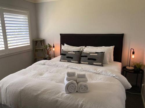 a bedroom with two towels on a white bed at Ralphie’s Villa 2 bed 2 bath with Valley views in Kangaroo Valley