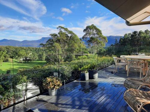 an outdoor deck with a table and chairs and mountains at Ralphie’s Villa 2 bed 2 bath with Valley views in Kangaroo Valley