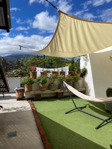 a hammock on a balcony with potted plants at Hotel Hasta La Vista in Antigua Guatemala