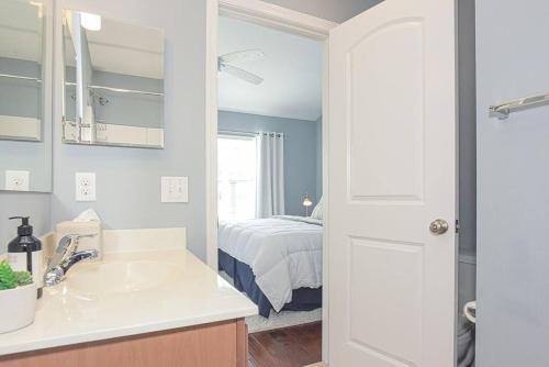 a bathroom with a sink and a bed in a room at Rehoboth Crossing - Beach Oasis! in Rehoboth Beach
