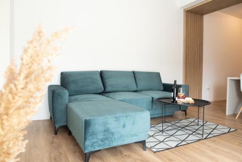 a living room with a blue couch and a table at Alternativ 2 Residence Central in Timişoara