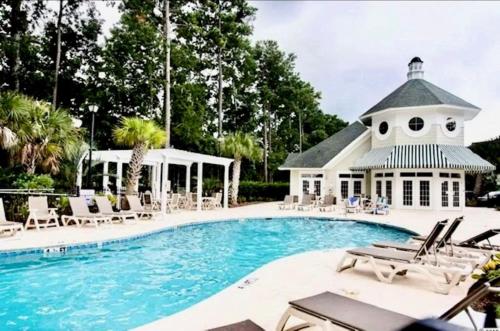 a swimming pool with chairs and a building at Great Golf View Condo WT 3th Floor in Myrtle Beach