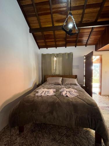 une chambre avec un grand lit avec deux serviettes dessus dans l'établissement chale ype, à Monte Verde