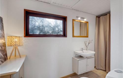 La salle de bains blanche est pourvue d'un lavabo et d'une fenêtre. dans l'établissement Awesome Home In Blvand With 3 Bedrooms And Wifi, à Blåvand