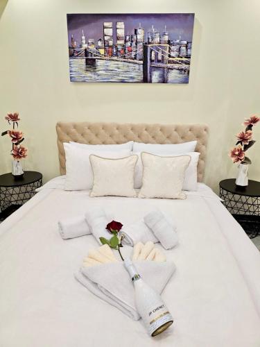 a white bed with towels and a rose on it at Andjela Lux in Vrnjačka Banja
