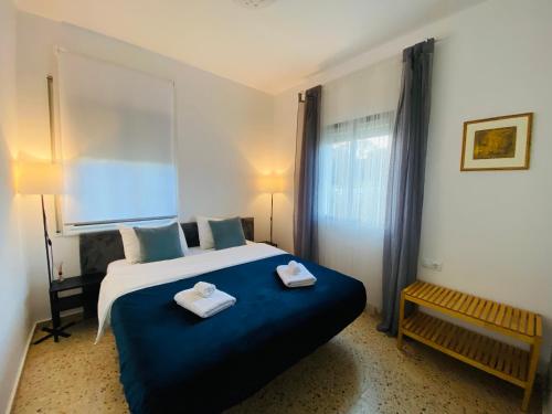 um quarto com uma cama grande e toalhas em Charming apartment in a duplex with garden & balcony em Cunit
