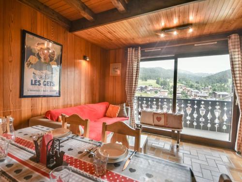 un salon avec un canapé et une grande fenêtre dans l'établissement Appartement duplex cosy pour 6-8 personnes avec parking - FR-1-685-21, aux Gets