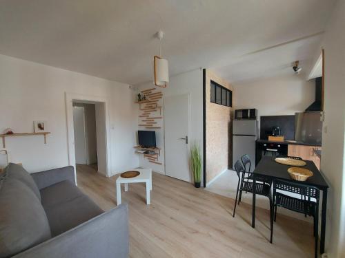 salon z kanapą i stołem w obiekcie Appart'Hotel la Savoureuse w Belfort