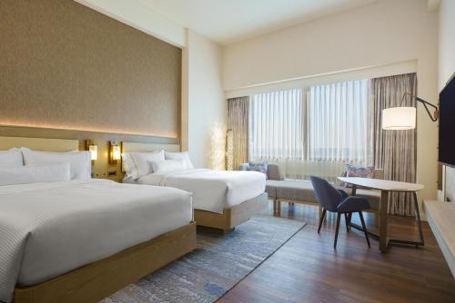 ローズモントにあるザ ウェスティン オヘアのベッド2台とデスクが備わるホテルルームです。