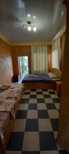 a bedroom with two beds and a checkered floor at ВИКЕНД in Karolino-Buhaz