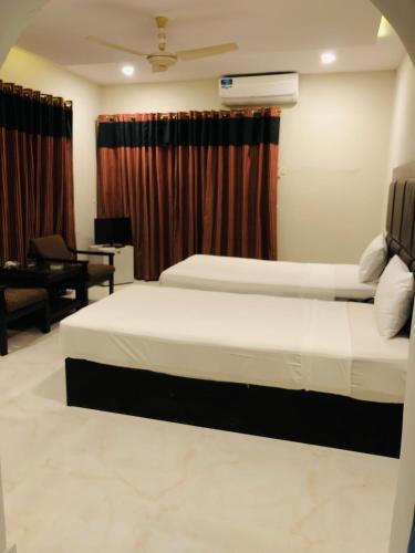 a hotel room with two beds and a desk at Star House in Islamabad