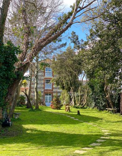 a green yard with trees and a building at Lala Mundi in Brading
