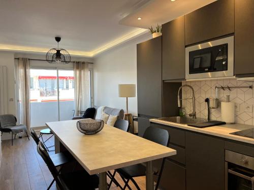 une cuisine avec une table et une salle à manger dans l'établissement Cosy 2 bedrooms apartment Croisette, à Cannes