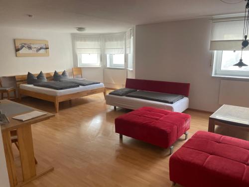a living room with two beds and a red couch at Lissi Apartment nur 5 Min vom Europa Park und direkt am Naturschutzgebiet in Kappel-Grafenhausen