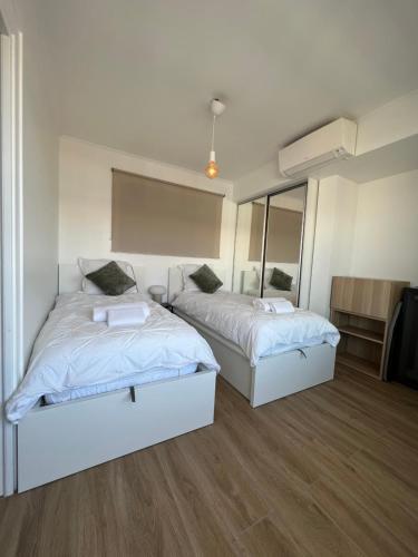une chambre avec deux lits et un miroir dans l'établissement Cosy 2 bedrooms apartment Croisette, à Cannes