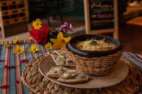a bowl of soup and bread on a table with flowers at Viajero Salento Hostel in Salento