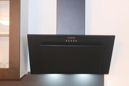 a black microwave oven sitting on top of a counter at la lapia in Monthey